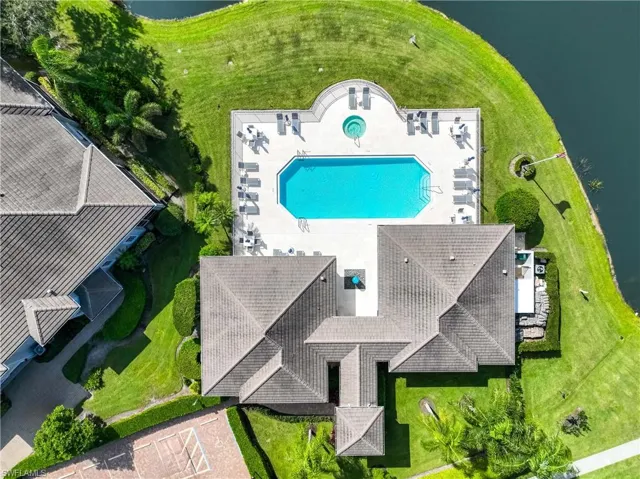Drone / aerial view of a pool area and a nearby body of water