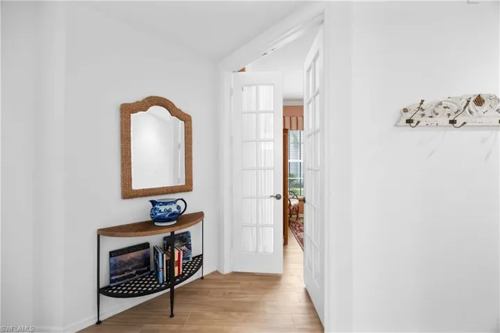 Corridor with light wood-style floors and baseboards