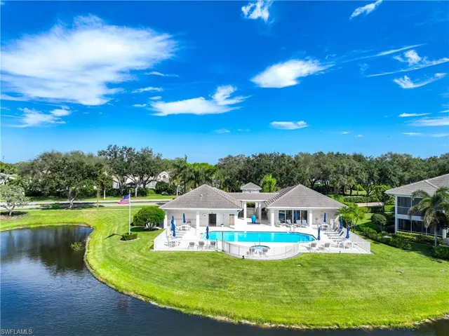Back of property featuring a patio, a yard, a water view, and a community pool