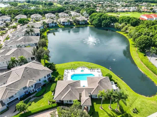 Aerial perspective of suburban area with a nearby body of water and a pool area