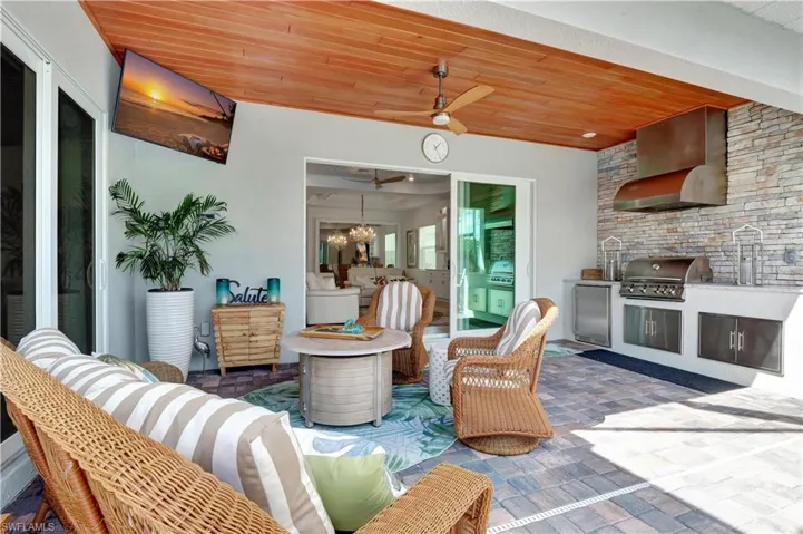 View of patio / terrace featuring exterior kitchen, a grill, sink, and ceiling fan