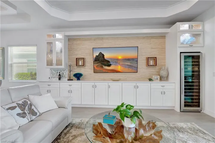 Living room featuring wine cooler and a tray ceiling