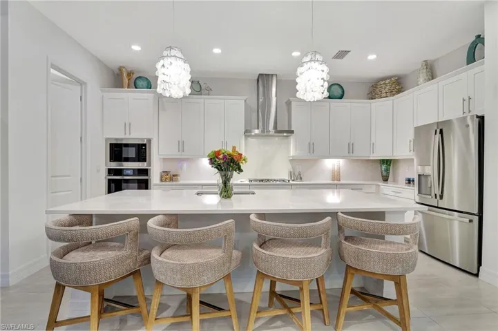 Kitchen featuring Island Seating and Custom Quartz Counters and Designer Lighting