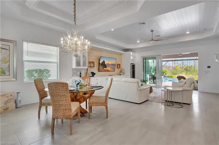 Dining Area with Raised wood ceiling, a wealth of natural light, and Light Tile Patterned Flooring