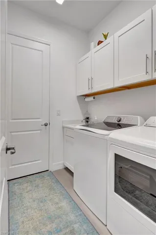 Laundry room with cabinets, sink, and washer and dryer