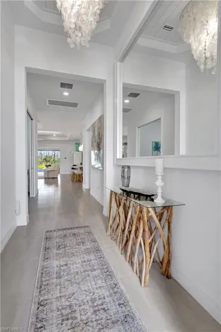 Corridor with an inviting chandelier and light tile patterned floors
