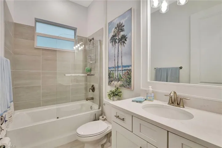 Full bathroom with toilet, vanity, and tiled shower / bath