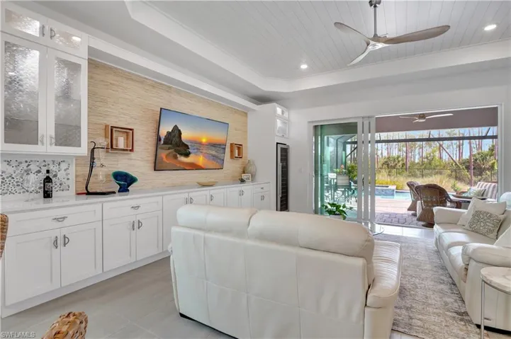 Living Room featuring Ship-lap wood Ceiling, Ceiling fan, a Tray Ceiling, and Wine Cooler