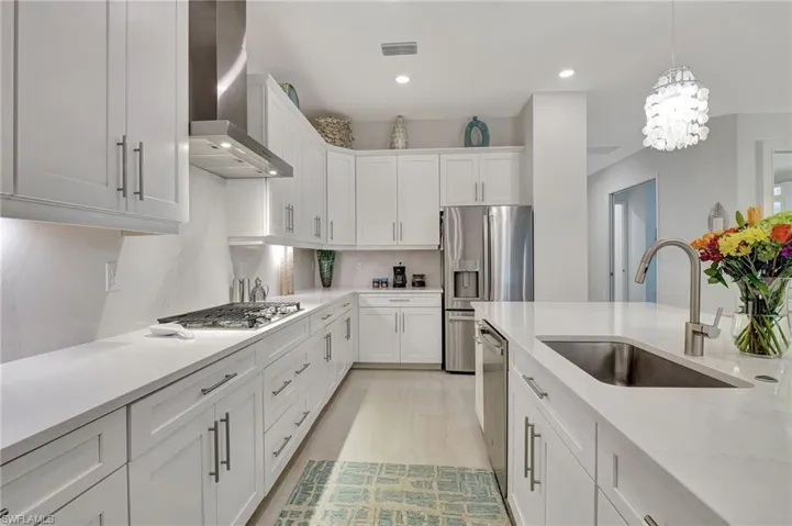 Kitchen showcasing White Soft Close Cabinetsand drawers as well as a wall chimney exhaust hood, and stainless steel appliances