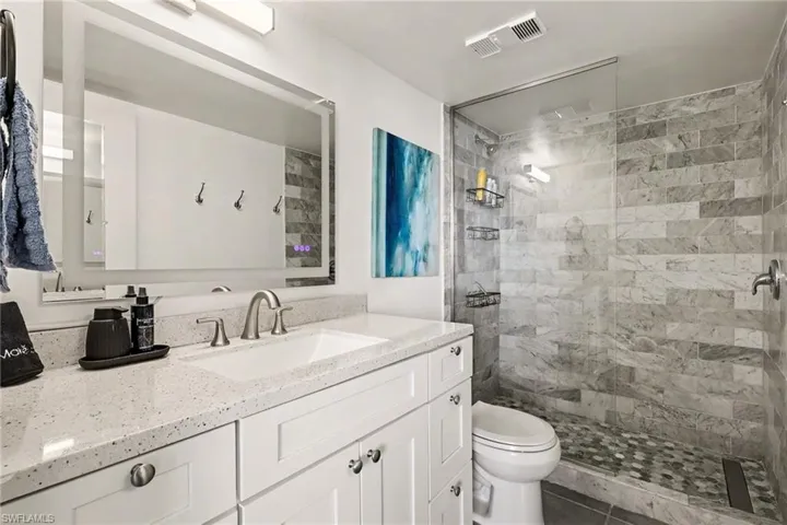 Bathroom with vanity and tiled shower