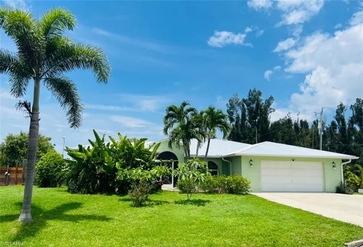 View of front of property featuring a garage and a front yard