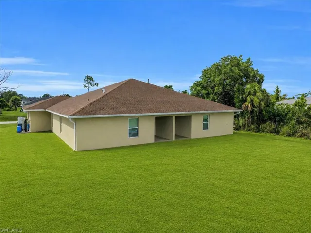 Exterior showcasing a hip roof, stucco siding, multiple windows, and covered outdoor spaces
