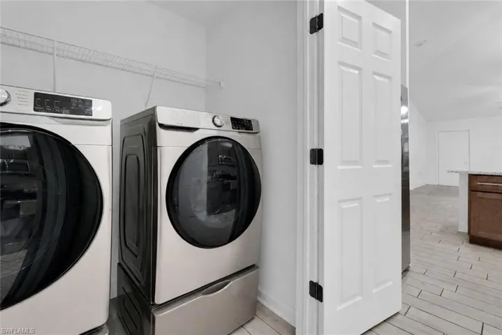 Laundry area featuring tile flooring and a wire storage shelf
