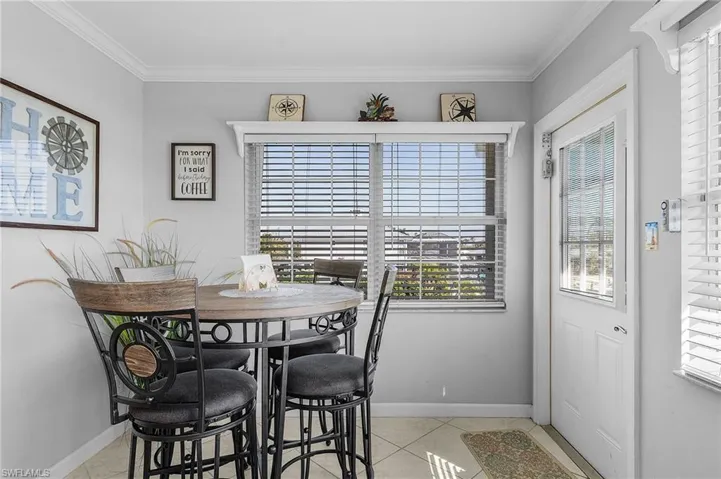 Dining area featuring ornamental molding and light tile patterned floors