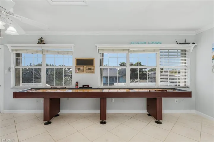 Game room featuring light tile patterned flooring, ornamental molding, and ceiling fan
