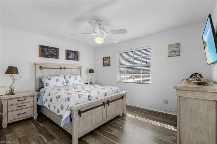 Bedroom with ceiling fan and dark hardwood / wood-style flooring