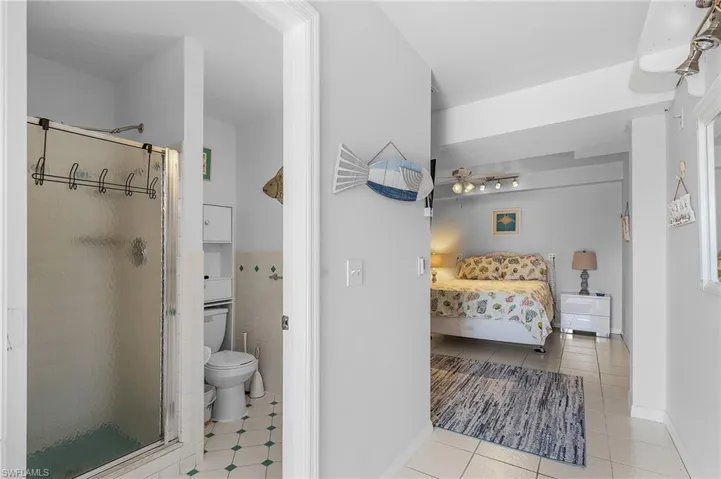 Bedroom with connected bathroom and light tile patterned floors