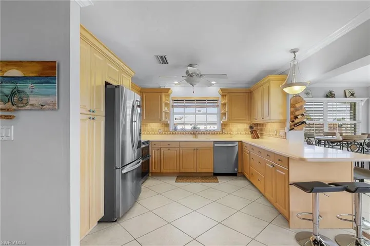 Kitchen with plenty of natural light, tasteful backsplash, appliances with stainless steel finishes, and kitchen peninsula