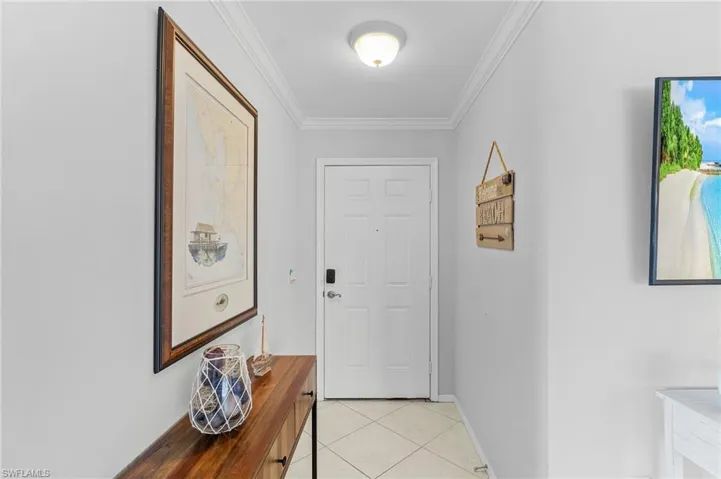 Entryway featuring crown molding and light tile patterned floors