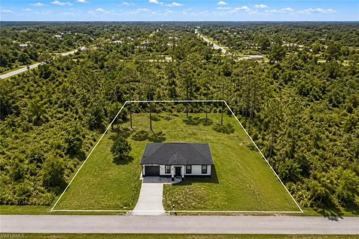 Aerial perspective showcasing a single-story residence with a dark shingle roof, light-colored exterior siding, and an attached garage