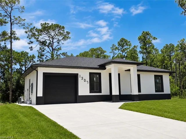 Contemporary white exterior with a contrasting black base, featuring a dark shingle roof, black garage door, and a covered entry with white columns