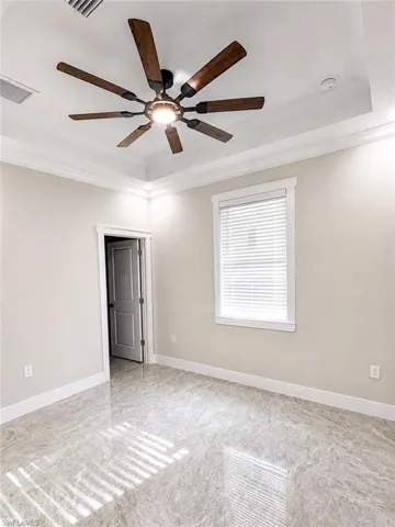 Tray ceiling featuring a wood-finish ceiling fan with integrated lighting