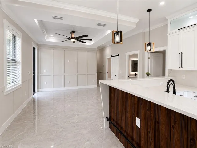 Open-concept living area featuring a tray ceiling, recessed lighting, and a modern ceiling fan