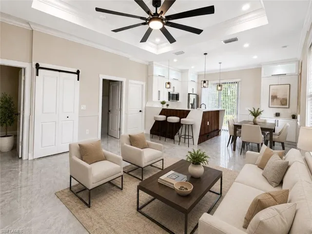 Open-concept living space featuring high ceilings with crown molding, recessed lighting, and a contemporary ceiling fan