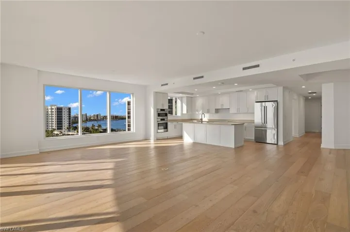 Large great room with lots of natural lighting coming through the sliding glass doors and floor to ceiling windows