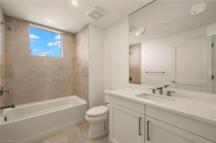 Bathroom 3 featuring vanity, bathing tub / shower combination, light tile patterned floors, and recessed lighting
