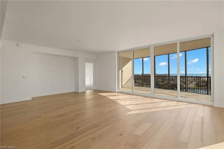 floor to ceiling windows all around and light wood finished floors