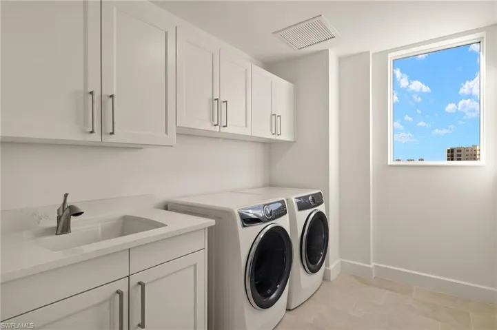 Lots of cabinets space in the laundry room with full size washer and clothes dryer