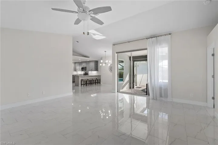 Spare room with lofted ceiling and ceiling fan with notable chandelier