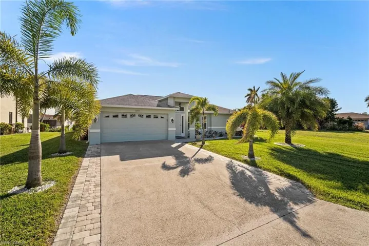 Ranch-style house with a garage and a front lawn