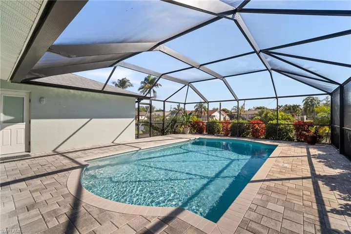 View of pool featuring a patio and glass enclosure