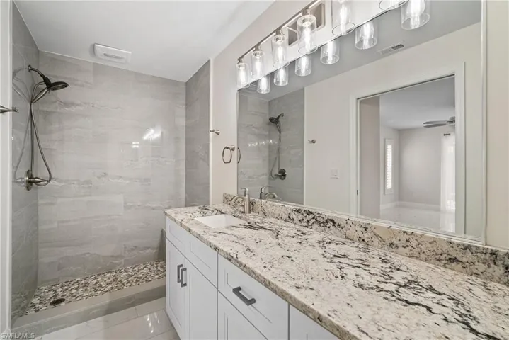 Bathroom featuring vanity and a tile shower