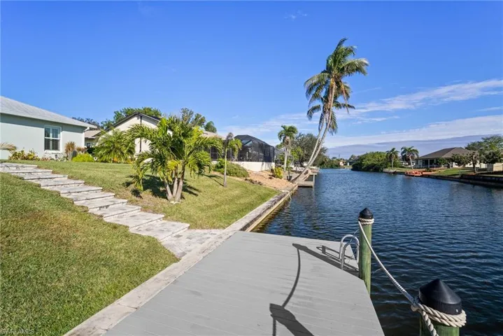 View of dock with a water view and a yard