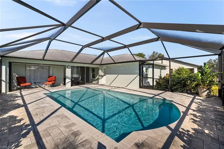 View of pool featuring a patio area and glass enclosure