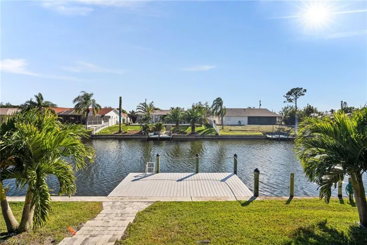 Dock area featuring a water view and a lawn