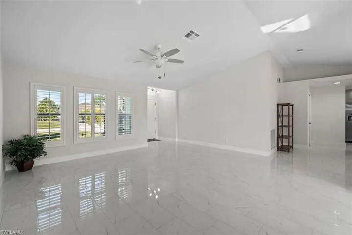 Empty room featuring lofted ceiling and ceiling fan