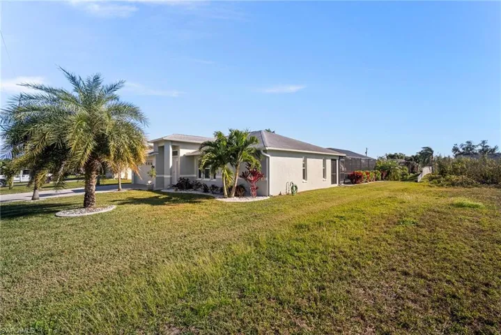 View of home's exterior featuring a lanai and a yard