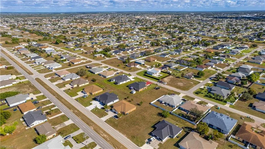 Aerial view of duplex lot  and surrounding area featuring nearby suburban area