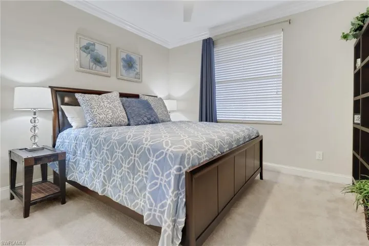 Bedroom featuring light colored carpet and ornamental molding