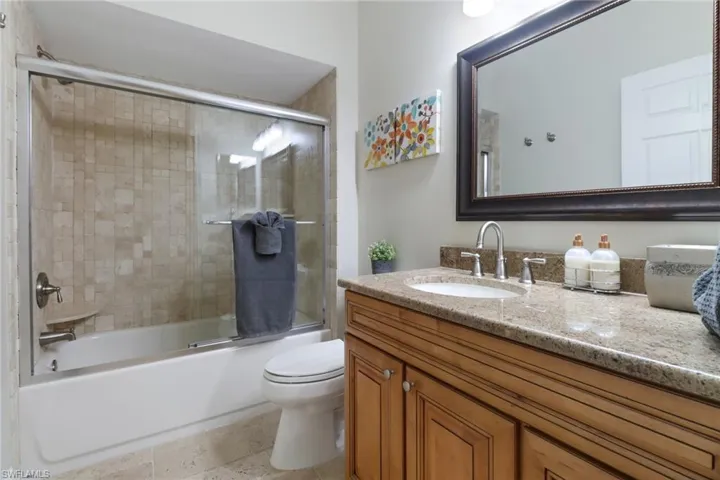 Full bathroom with vanity and enclosed tub / shower combo