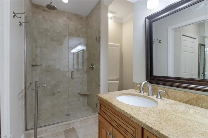 Full bathroom with vanity, a stall shower, and ornamental molding