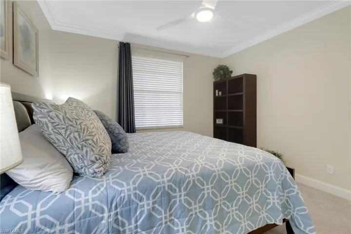 Bedroom with carpet, crown molding, and a ceiling fan