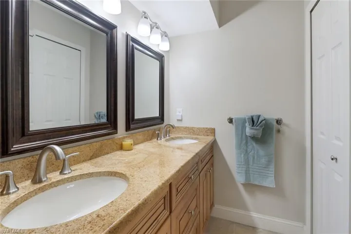 Full bathroom with double vanity and baseboards