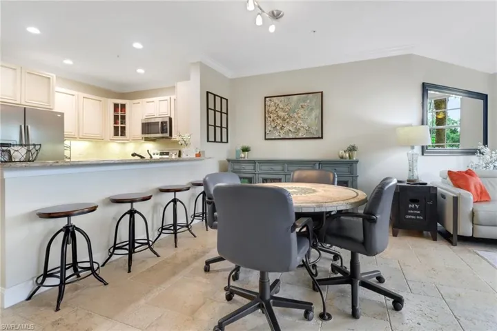 Dining space featuring stone tile flooring, crown molding, and recessed lighting