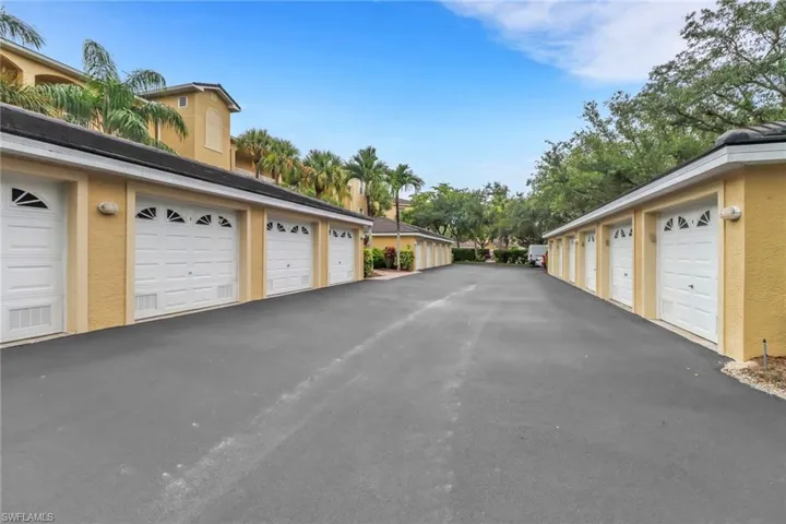 View of asphalt road with community garages