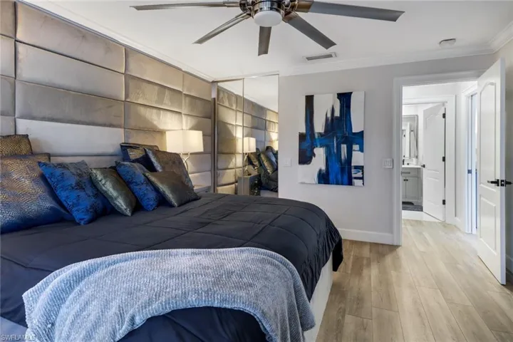 Bedroom with ornamental molding, a closet, ceiling fan, and light wood-type flooring